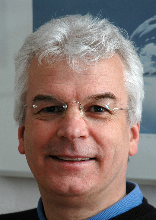 Profilbild von Gert Stührmann mit blau-weißem Bild im Hintergrund